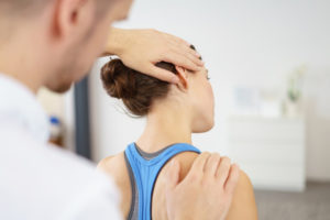 Physiotherapeut behandelt die Halswirbelsäule einer Patientin – Manuelle Therapie bei Reinker